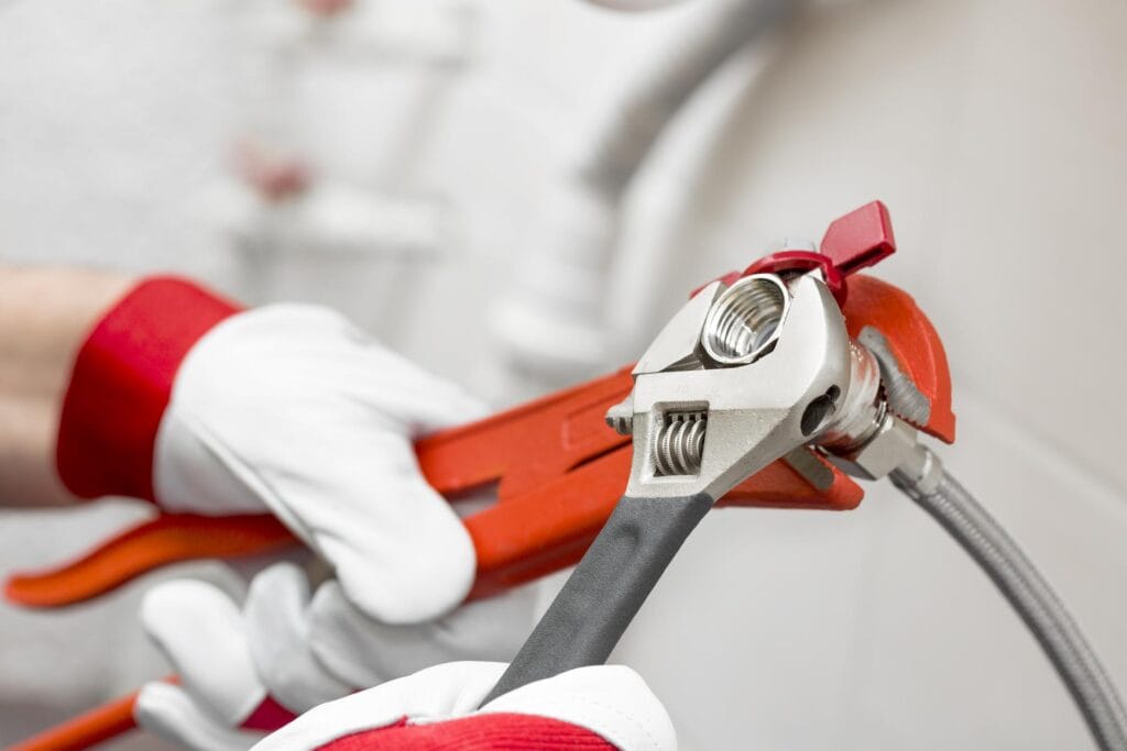 Plumber tightening pipe fitting for residential plumbing repair in Dunedin, Florida