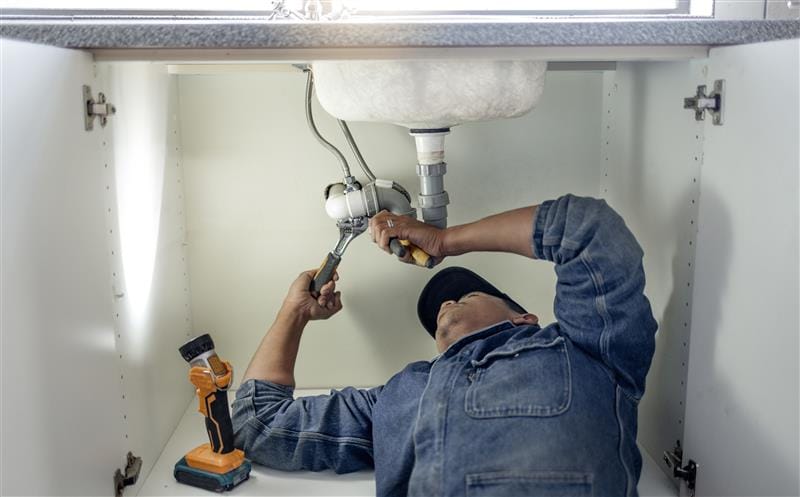 Plumber repairing kitchen sink drain pipes in Dunedin, Florida