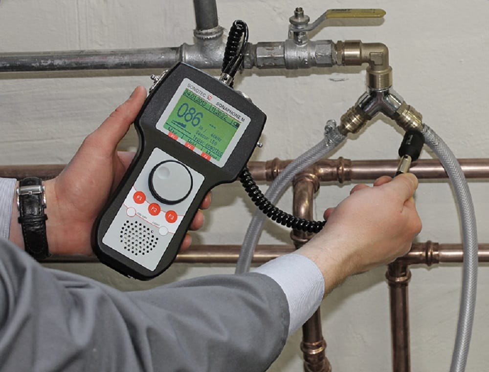 Plumber testing pipes with electronic leak detection equipment in Dunedin
